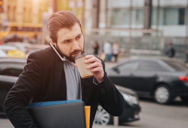 Homem ocupado está com pressa, ele não tem tempo, ele vai comer lanche em movimento. Trabalhador comendo, tomando café, falando ao telefone, ao mesmo tempo. Empresário, fazendo várias tarefas.