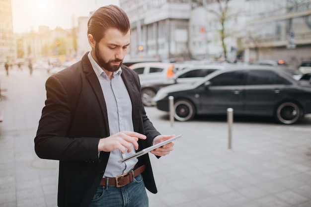 Homem ocupado está com pressa, ele não tem tempo, ele vai usar o tablet pc em movimento. empresário, fazendo várias tarefas. pessoa de negócios multitarefa.