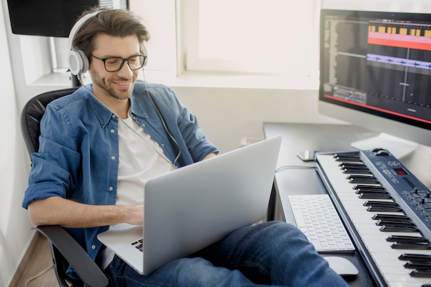 Homem ocupado trabalhando em um laptop no estúdio