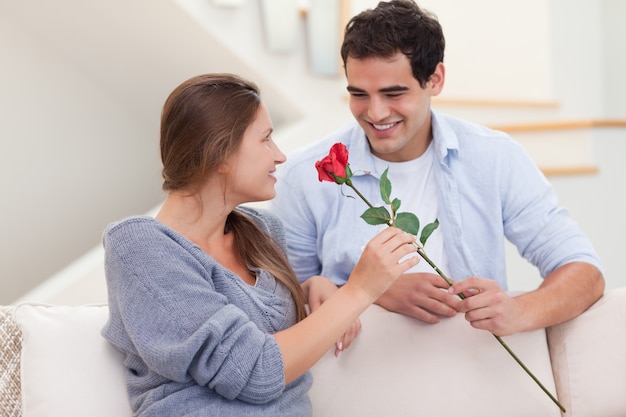 Homem oferecendo uma rosa para sua namorada