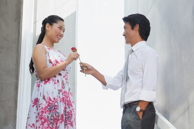 Homem oferecendo uma rosa vermelha para namorada