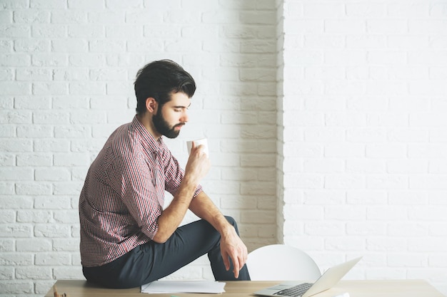 Homem olhando para a tela do laptop