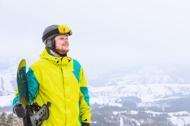Foto homem olhando para o espaço livre com roupa de esqui snowboard atividades radicais de inverno