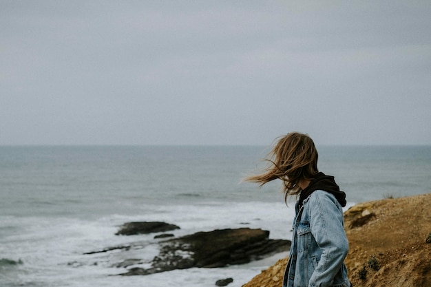 Foto homem olhando para o mar contra o céu