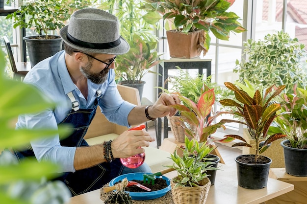 Foto homem olhando para plantas em vaso na mesa