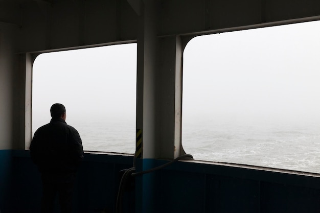 Foto homem olhando pela janela do barco