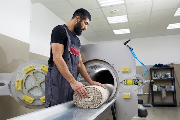 Homem operando máquina de secagem para limpeza de carpetes. serviço profissional de limpeza de carpetes