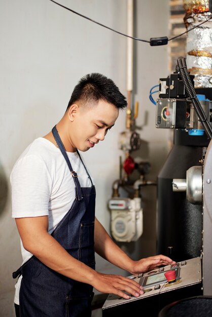 Homem operando máquina de torrefação de café