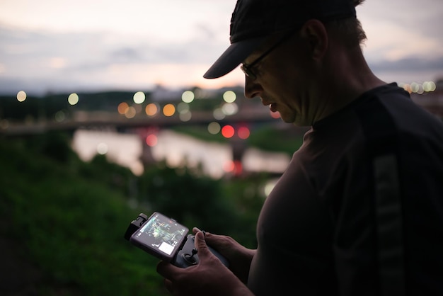 Foto homem operando um drone usando um controle remoto homem voando drone