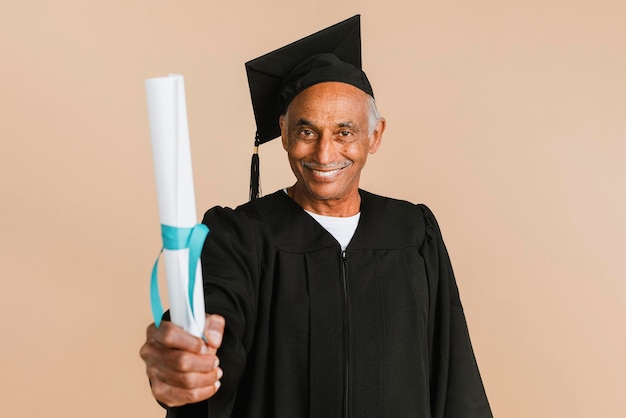 Homem orgulhoso do último ano em um vestido de formatura segurando seu diploma