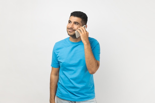 Homem otimista falando no celular tendo uma expressão positiva satisfeita desfrutando de conversa