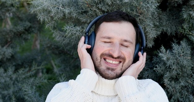 Homem ouvindo música com um suéter branco