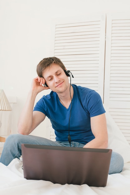 Homem ouvindo música em um laptop