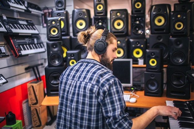 Foto homem oyung sério e concentrado criando música no estúdio