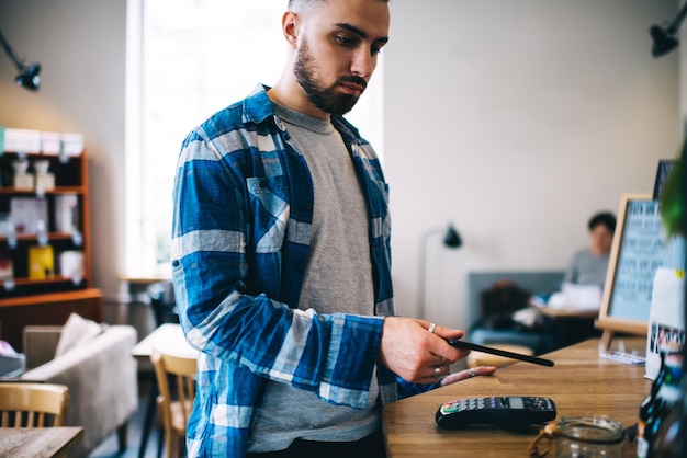 Homem pagando com smartphone no café