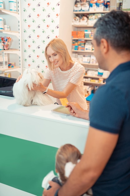 Homem pagando por cachorro com cartão ao comprá-lo para filha