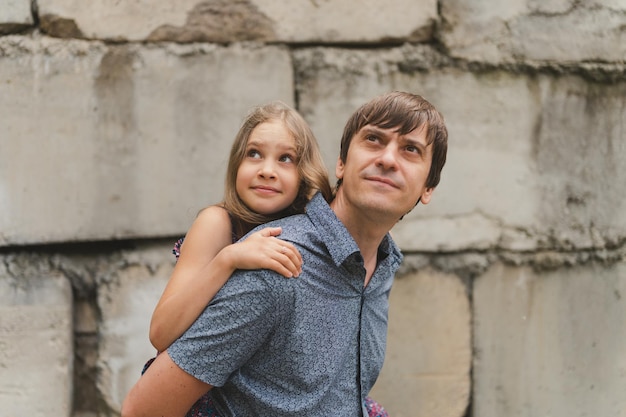 Homem pai tendo tempo de qualidade com sua filha filha menina de nove anos nas costas pai feliz brincando com criança vida real momentos de paternidade autênticos do dia de hoje amor paterno cuidado e carinho