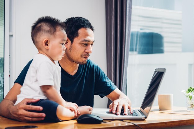 Homem pai trabalhando em laptop com filho em casa