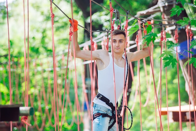 Foto homem passa seu tempo de lazer em um curso de cordas. homem envolvido no parque de corda.