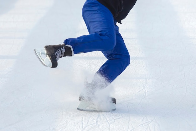 Homem patina ativamente em uma pista de gelo.