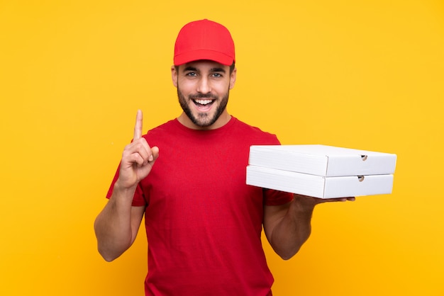 Homem pegando caixas de pizza sobre parede isolada