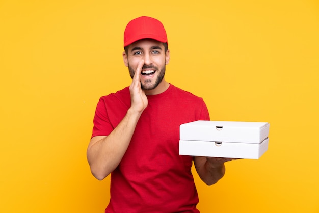 Homem pegando caixas de pizza sobre parede isolada