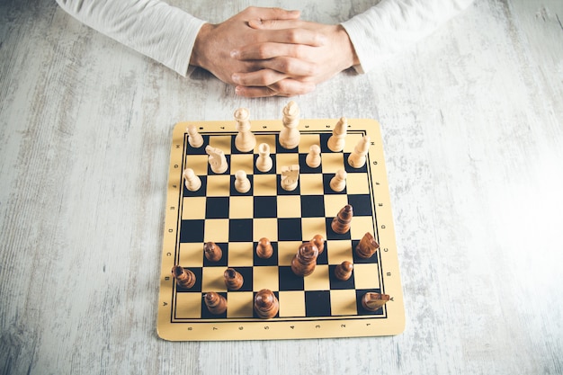 Foto homem pensante jogando xadrez na mesa