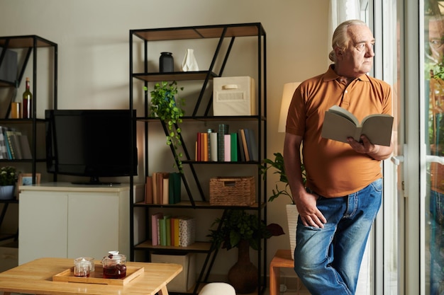 Foto homem pensativo com livro aberto