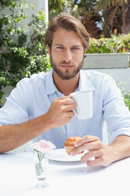 Homem pensativo que toma um café