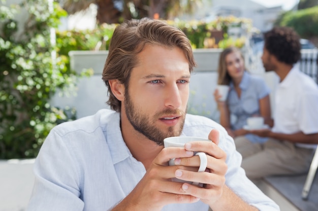 Homem pensativo que toma um café