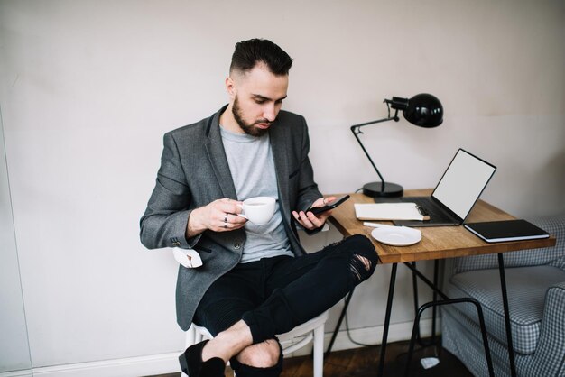 Homem pensativo usando dispositivos no trabalho