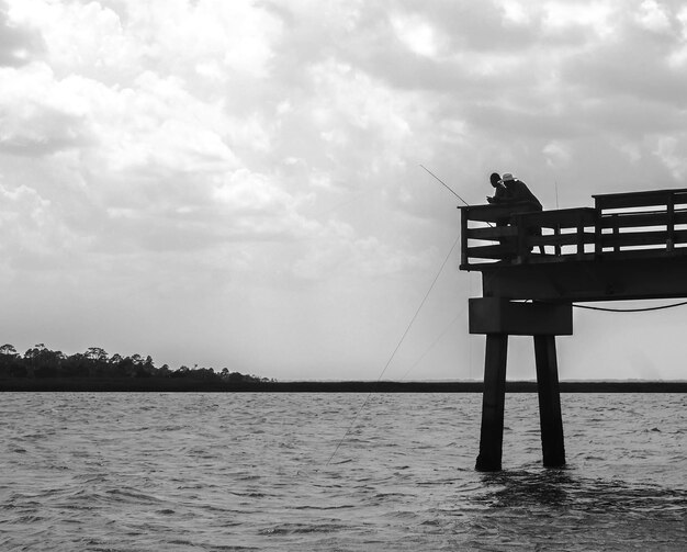 Foto homem pescando no mar contra o céu