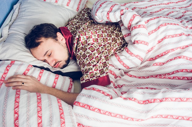 Homem pijama dormindo na cama