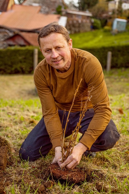 Homem planta árvore no jardim. Conceito de natureza, meio ambiente e ecologia.