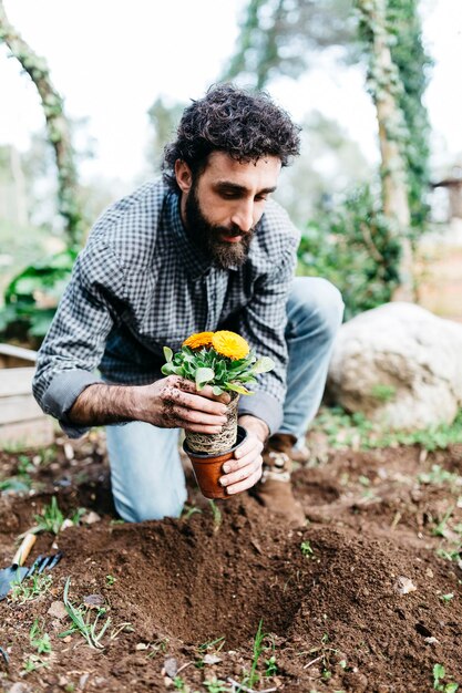 Foto homem plantando flores em seu jardim