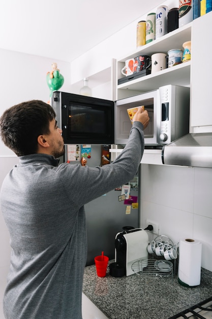 Homem, pôr, copo, dentro, microonda, forno