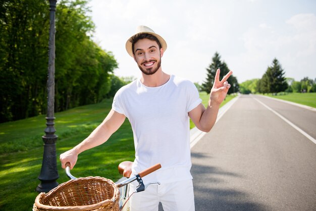 Homem posando ao ar livre com bicicleta