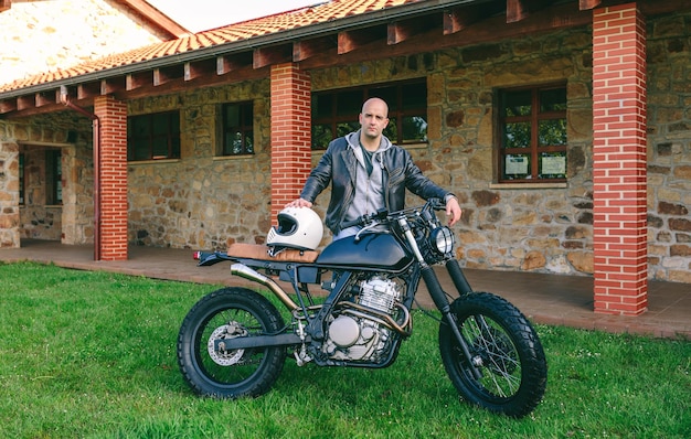 Homem posando com uma moto personalizada