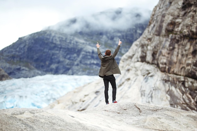 Homem posando no fundo das montanhas na Noruega Man turista caminhando para o belo lago de montanha