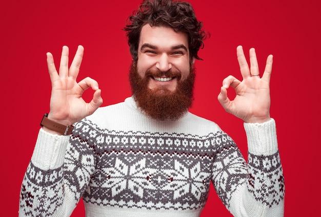 Foto homem positivo com suéter de inverno mostrando sinal de ok