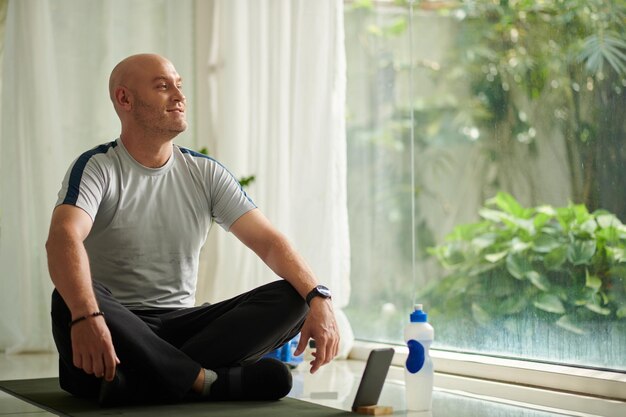 Homem praticando Yoga em casa