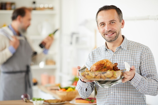 Homem preparado frango assado para o jantar