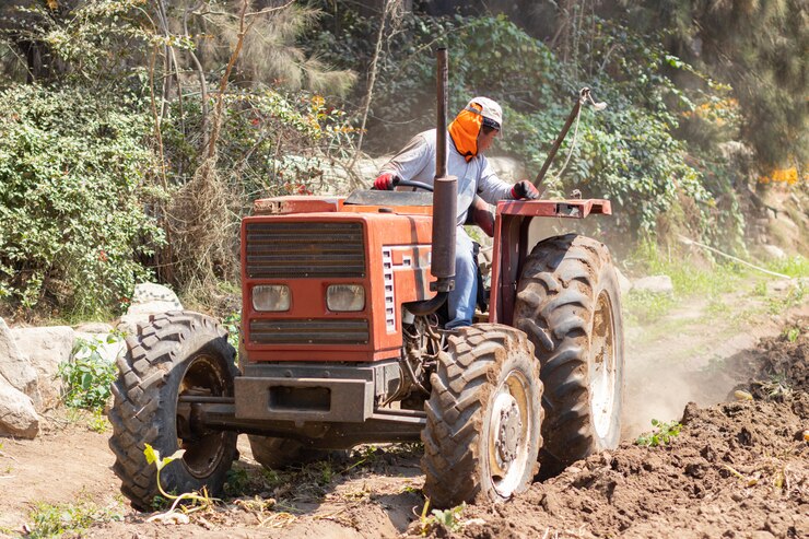 Foto homem preparando a terra para a colheita com o trator na fazenda
