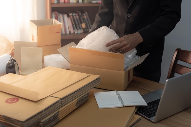 Homem preparando um pacote para entrega no escritório de vendas on-line ecommerce drop shipping
