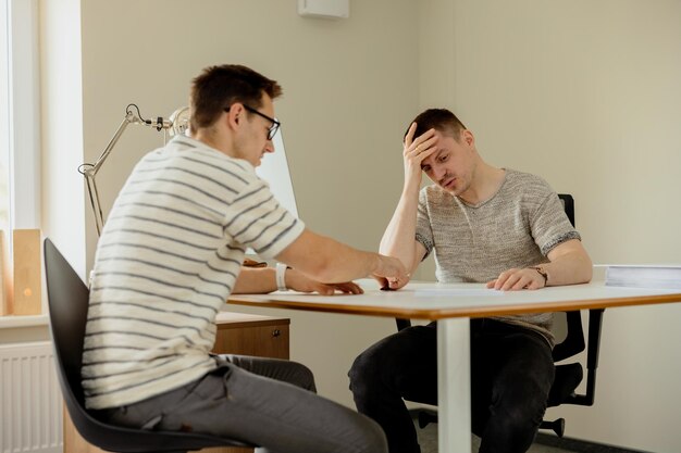 Homem profissional sério que consulta o cliente no escritório Dois homens tendo reunião fazendo conversa de negócios Seguradora dando conselhos gerente fazendo oferta Mentor ensinando estagiário Entrevista de emprego