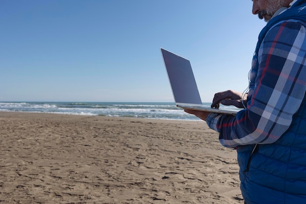 Homem profissional trabalhando em um laptop na praia