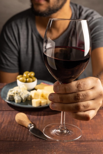 Foto homem provando vinho e queijo