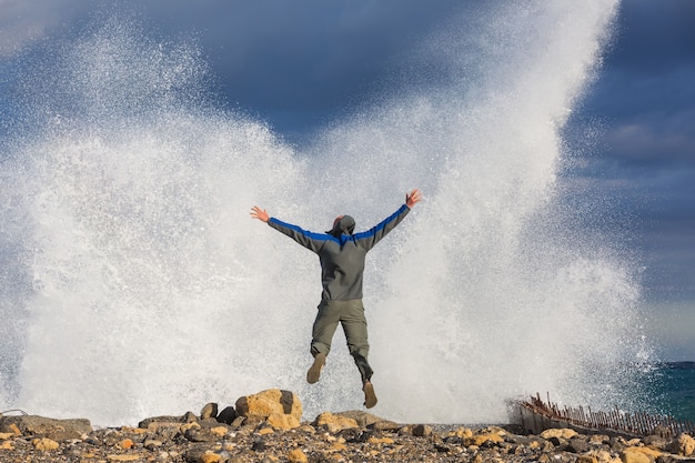 Homem pulando em ondas de tempestade dramáticas