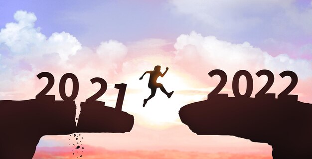 Homem pulando penhasco de 2021 a 2022 no fundo do céu da nuvem Feliz ano novo 2022