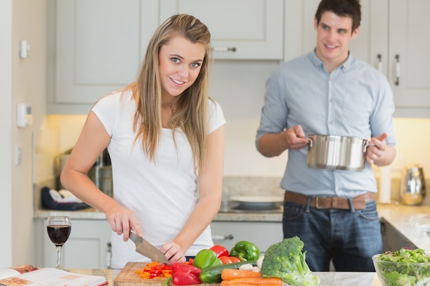 Homem que ajuda a mulher a preparar a refeição